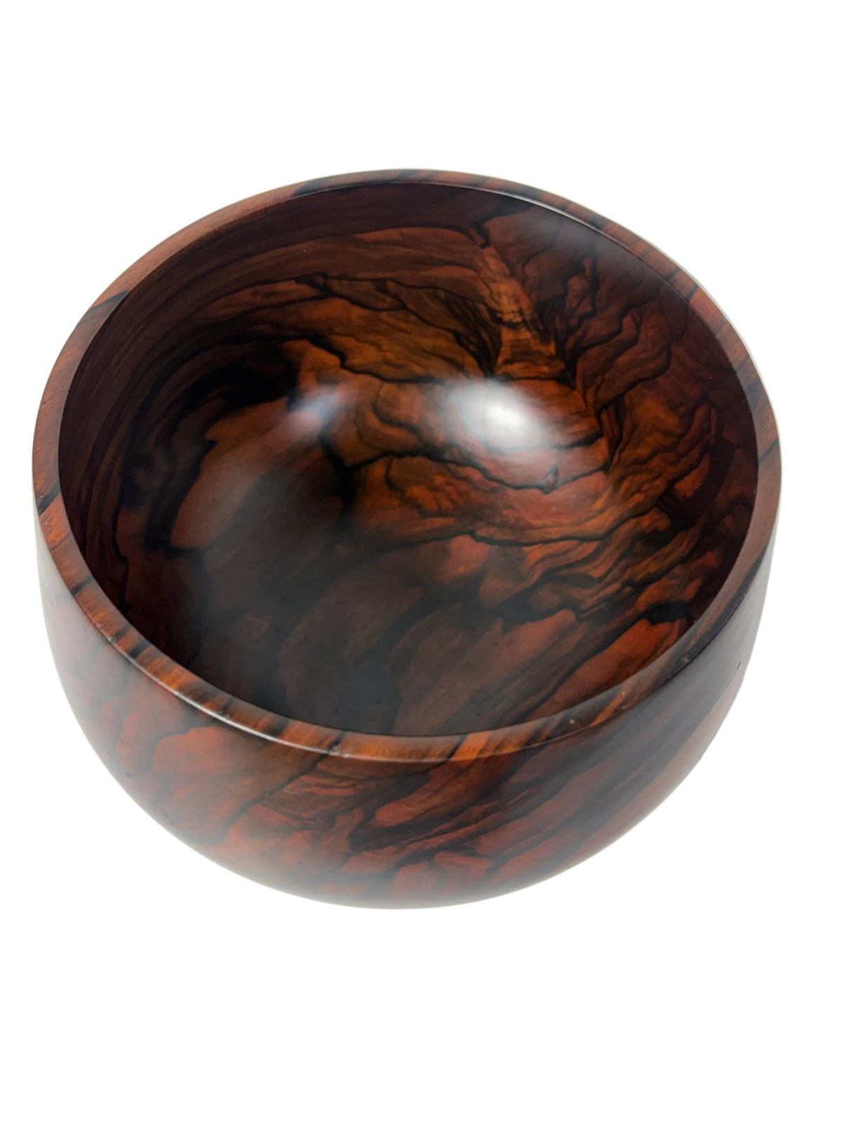 A round wooden bowl with a highly polished finish, showcasing dramatic dark and reddish-brown wood grain patterns, photographed from a top-down angle 